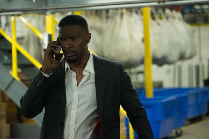 Jamie Foxx on the phone in a warehouse