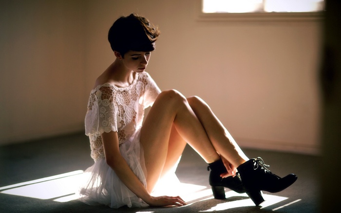 Woman in white lace dress sitting on floor