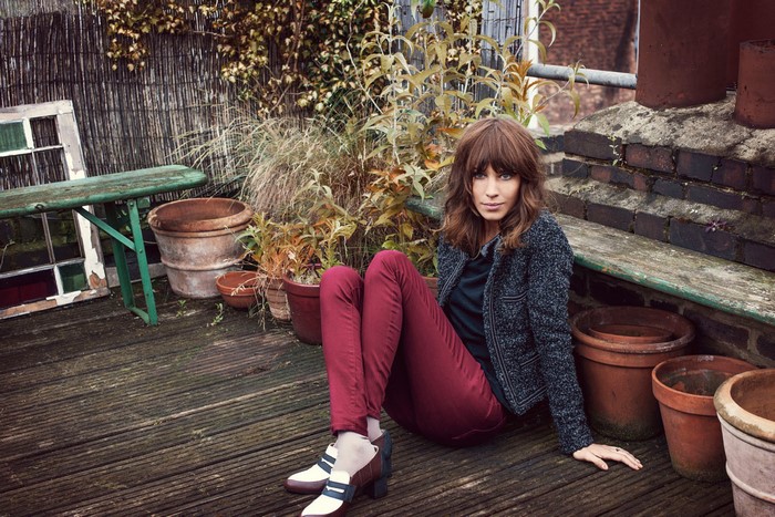 Alexa Chung sitting on a wooden deck