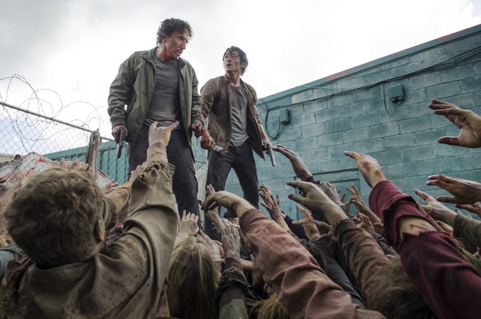 Steven Yeun and man surrounded by zombies