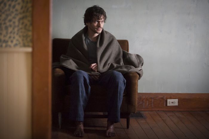 Hugh Dancy sitting wrapped in a blanket