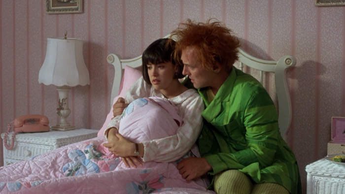 Rik Mayall and a woman in a bedroom