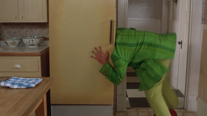Rik Mayall in a green suit stuck in a refrigerator