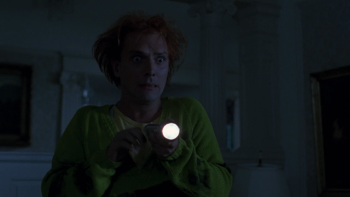 Rik Mayall holding a flashlight