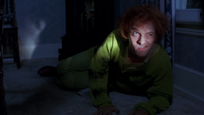 Rik Mayall in a green outfit on the floor