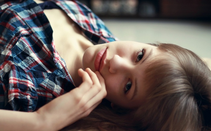 Young woman in plaid shirt lying down