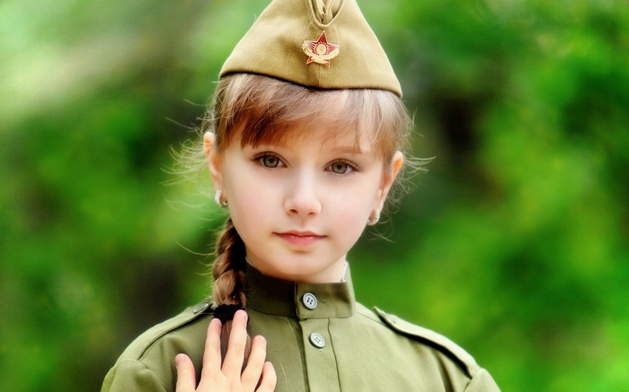 Young girl in military uniform and hat