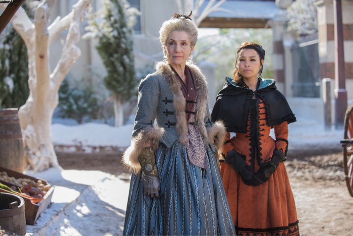Two women in historical costumes in a snowy outdoor setting