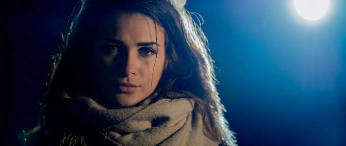 Woman in scarf under spotlight