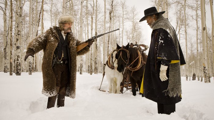 Kurt Russell in a snowy forest with horses