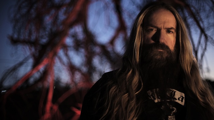 Zakk Wylde in front of a tree at dusk