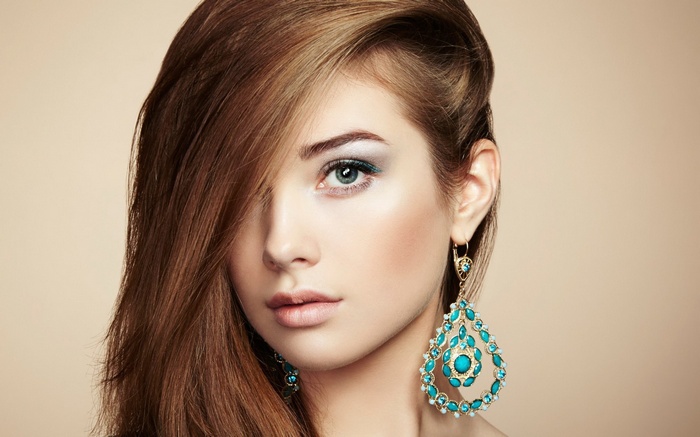 Woman with long brown hair and large turquoise earrings