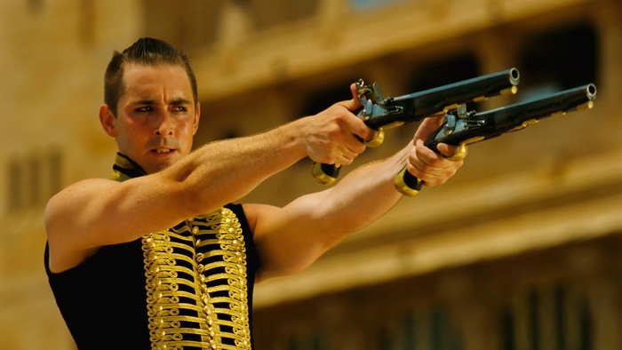 Lee Pace holding two flintlock pistols