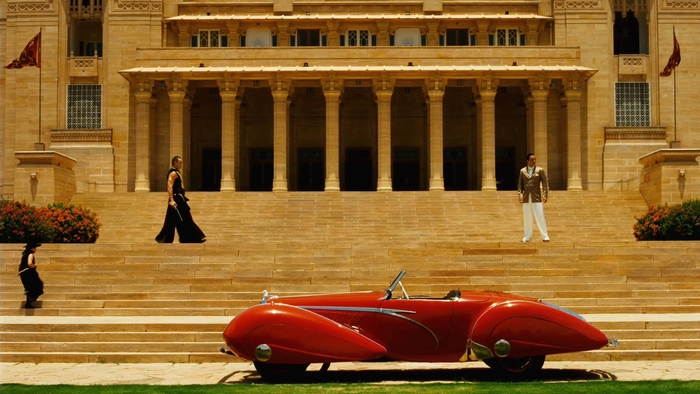 Lee Pace in a vintage car in front of a palace