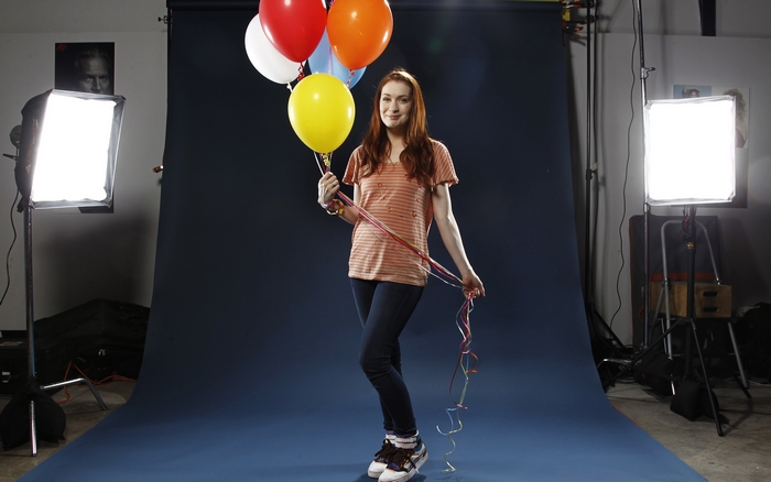 Felicia Day holding balloons in a studio