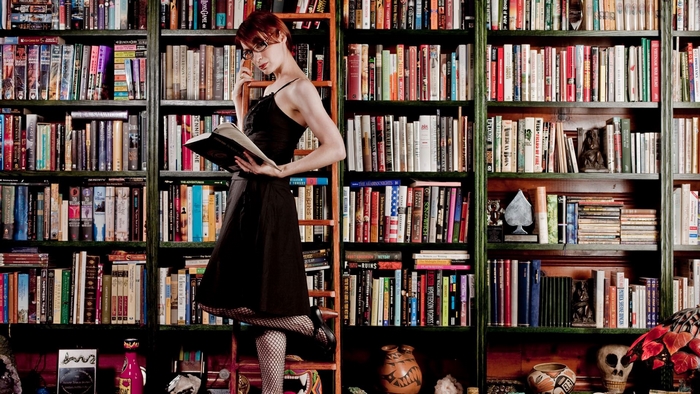 Felicia Day reading a book in a library