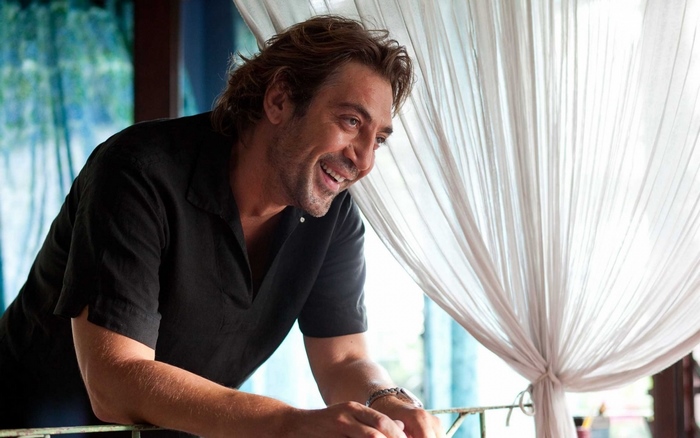 Javier Bardem smiling on a balcony