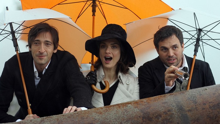 Rachel Weisz, Adrien Brody, and Mark Ruffalo under umbrellas