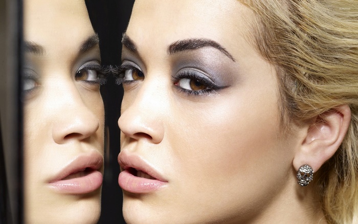Rita Ora looking into a mirror