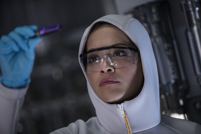 Rita Ora in protective gear holding a vial