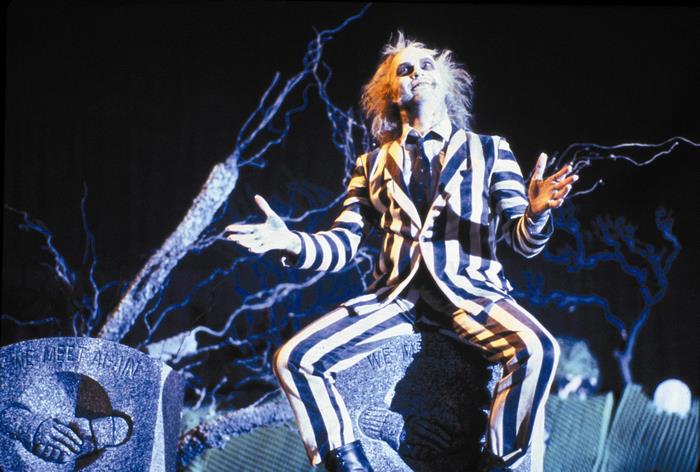 Michael Keaton as Beetlejuice on a tombstone