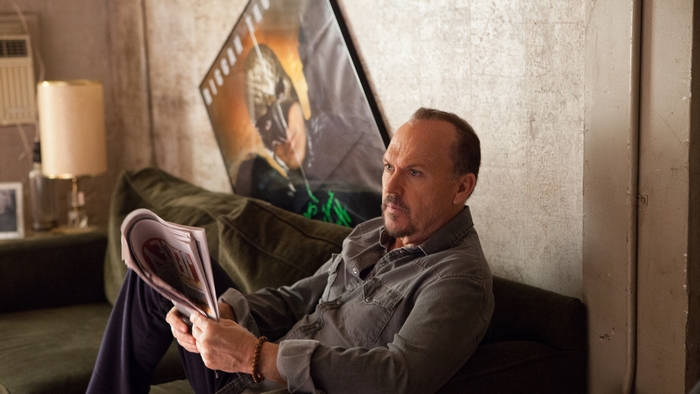 Michael Keaton reading a magazine on a couch