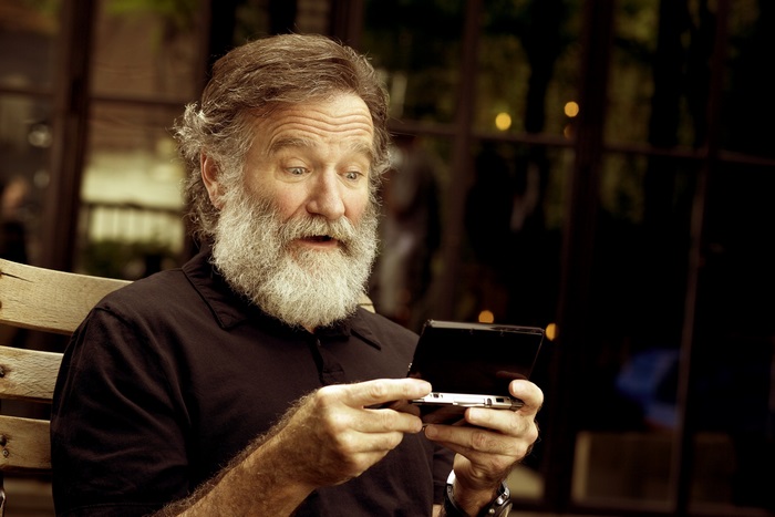 Robin Williams playing a handheld game