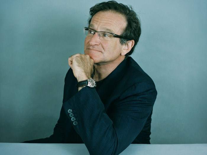 Robin Williams wearing glasses and a suit