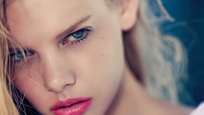 Close-up of a woman's face with bright pink lipstick