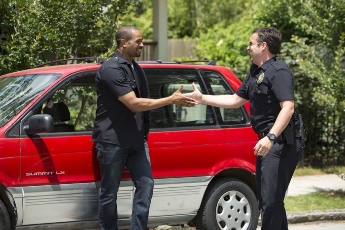 Damon Wayans Jr. and a police officer shake hands