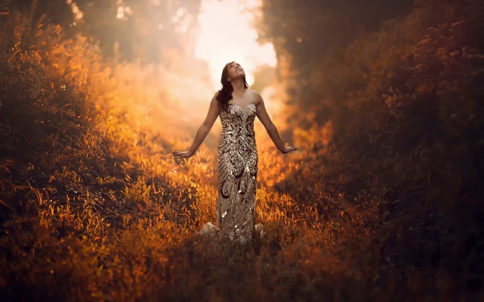 Woman in a sparkly dress in a sunlit forest