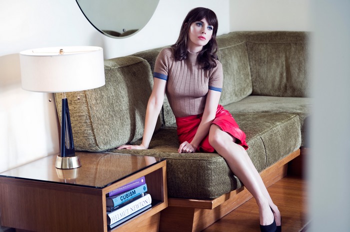 Alison Brie sitting on a couch