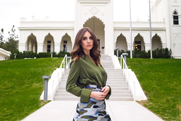 Alison Brie in front of a white building