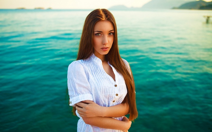 Woman in white shirt by the sea