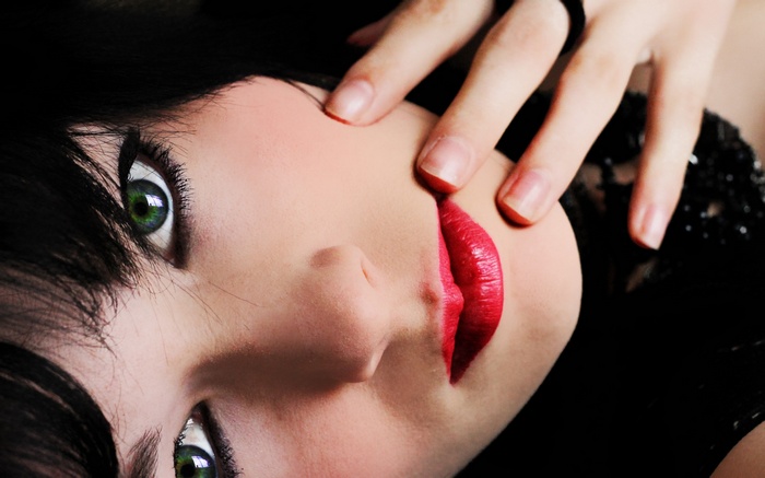 Close-up of a woman's face with green eyes and red lipstick
