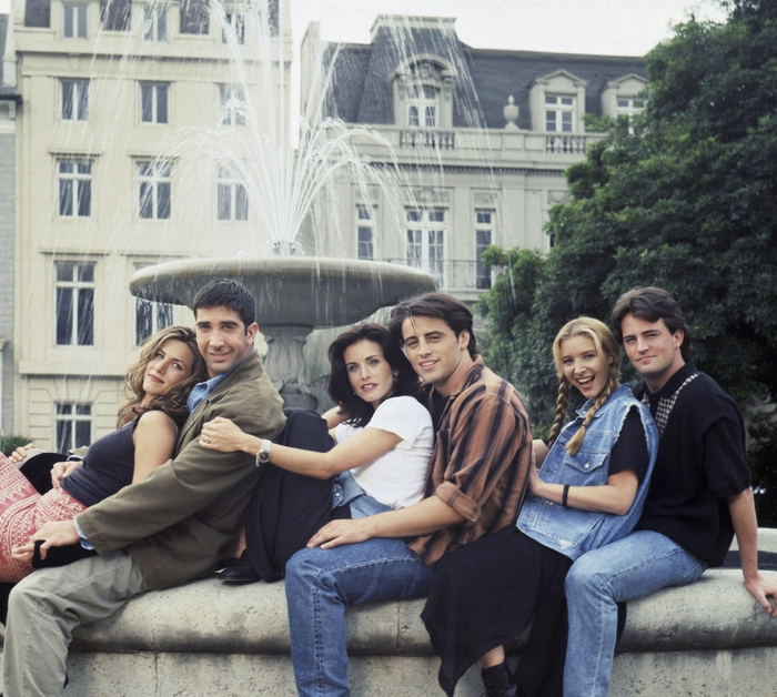 Friends cast sitting by a fountain