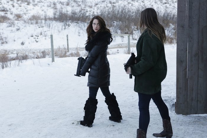 Melanie Scrofano holding guns in snow
