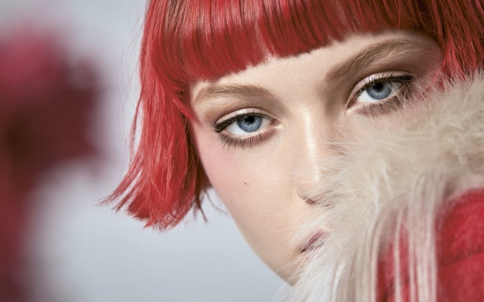Close-up of a woman with red hair and blue eyes
