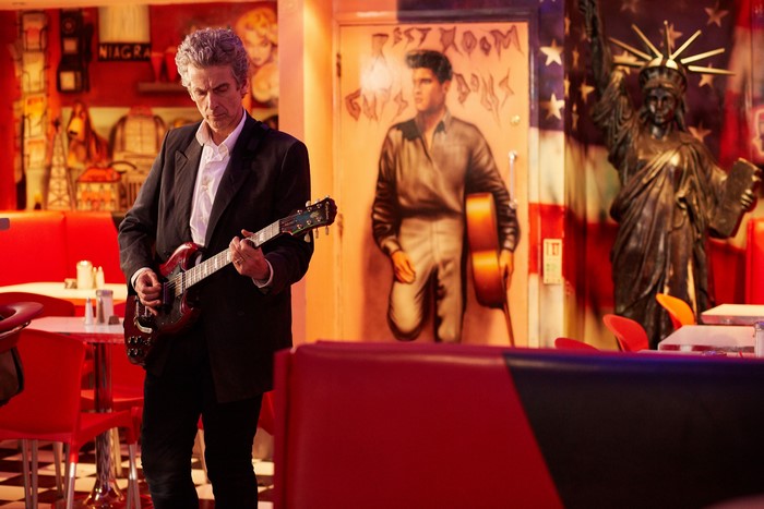Peter Capaldi playing guitar in a diner