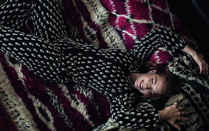 Rebecca Ferguson lying on a patterned rug