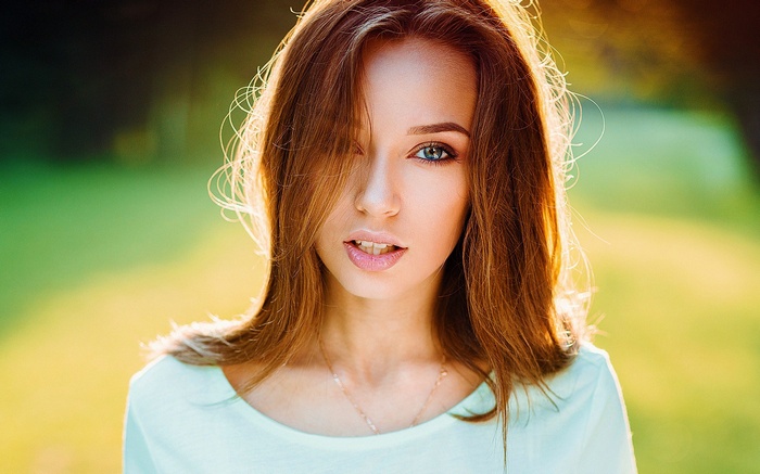 Woman with auburn hair in a light blue shirt