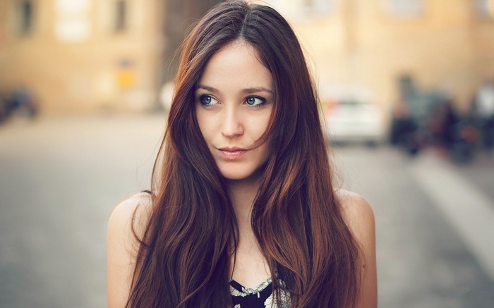 Woman with long brown hair looking to the side