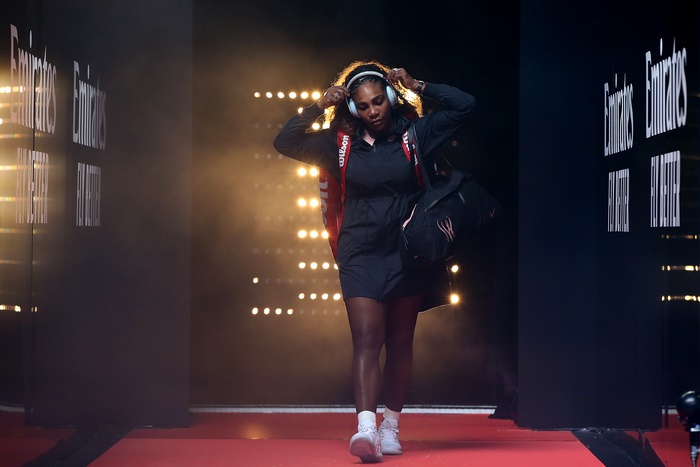 Serena Williams walking with headphones and bag