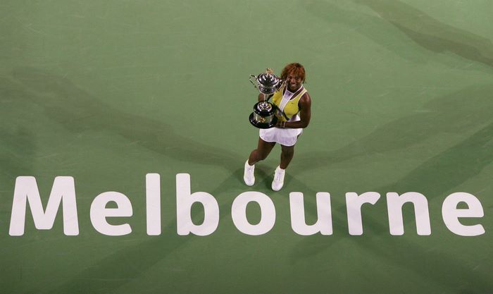 Serena Williams holding trophies on Melbourne court