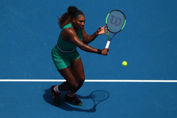 Serena Williams playing tennis on a blue court