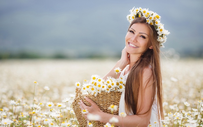 Woman with daisy crown and basket in a field