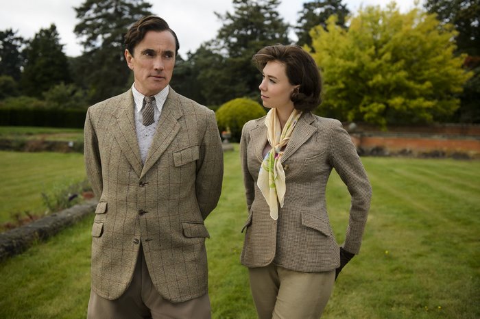 Vanessa Kirby and male actor in tweed jackets outdoors