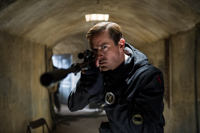 Armie Hammer aiming a sniper rifle
