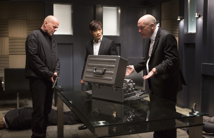 John Malkovich and two men with a briefcase