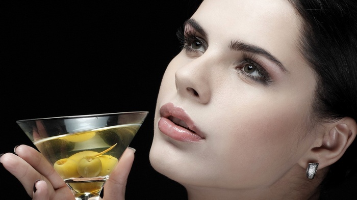 Woman holding a martini with olives